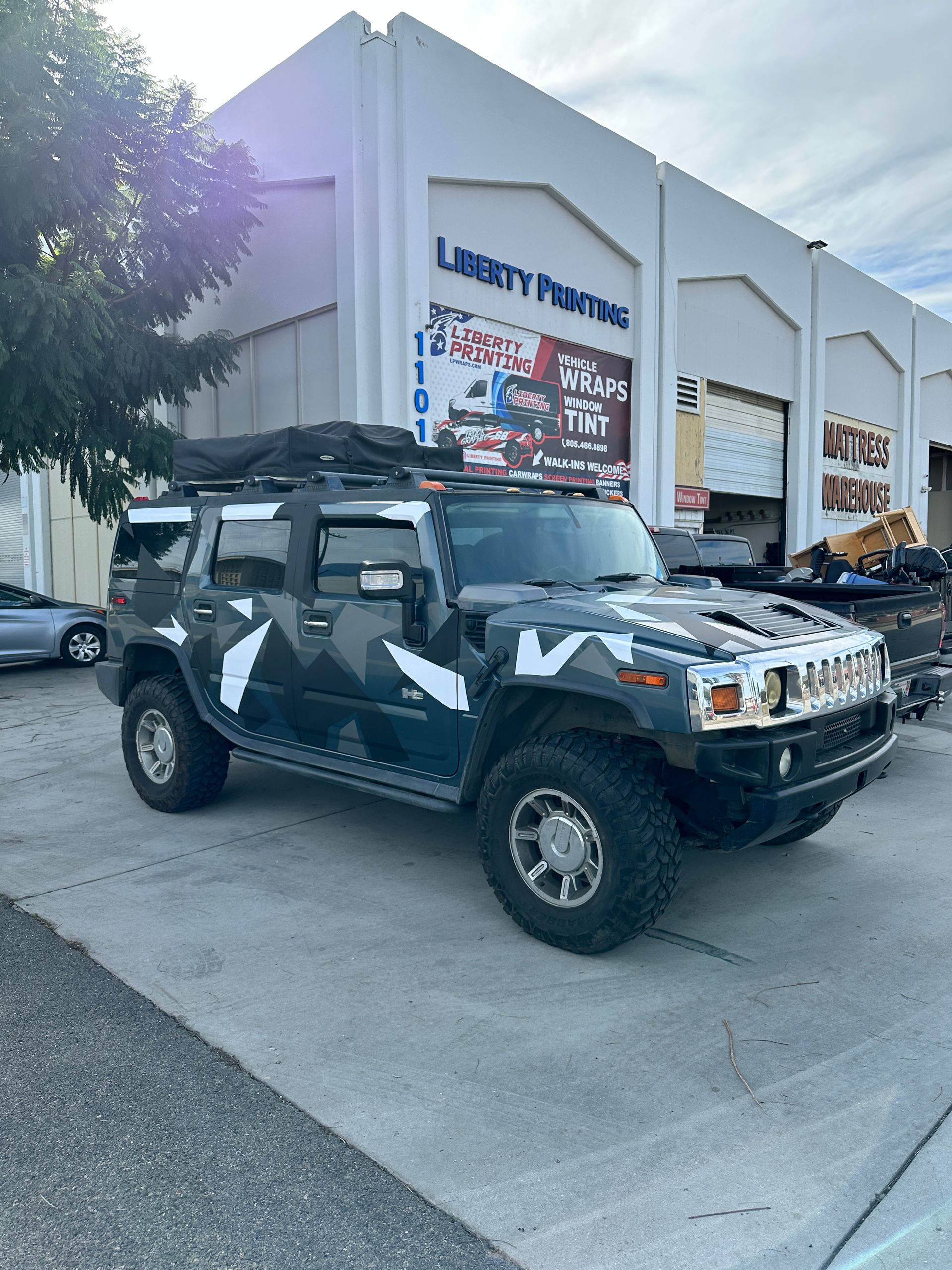 A hummer h2 is parked in front of a building.