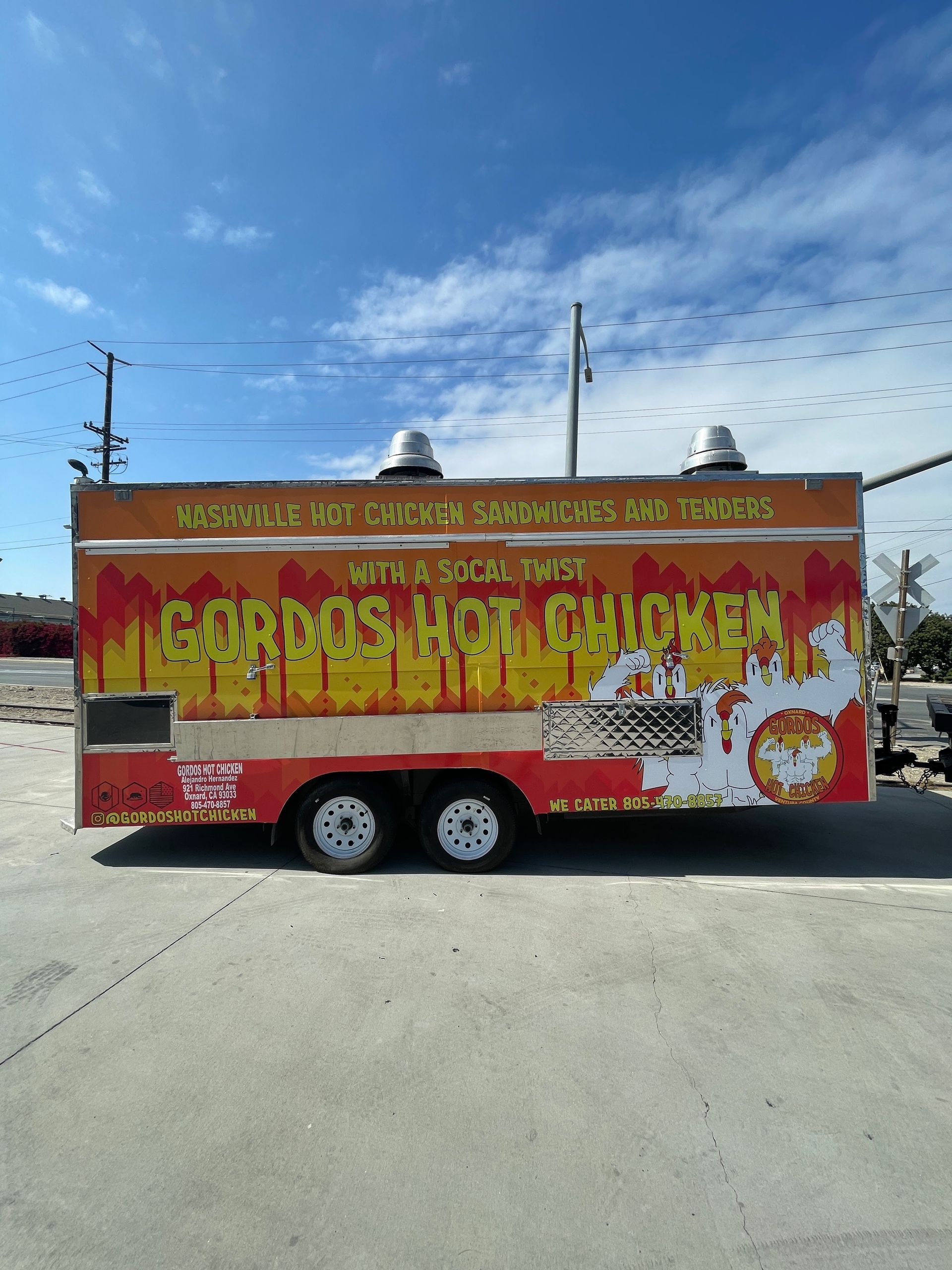 A food truck that says carros hot chicken on it