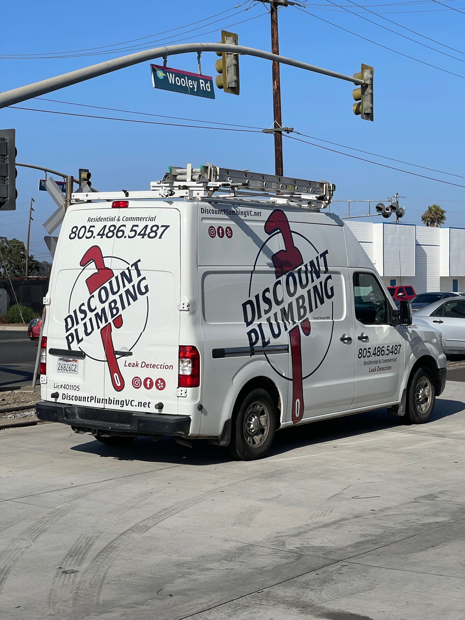 A discount plumbing van is parked on the side of the road