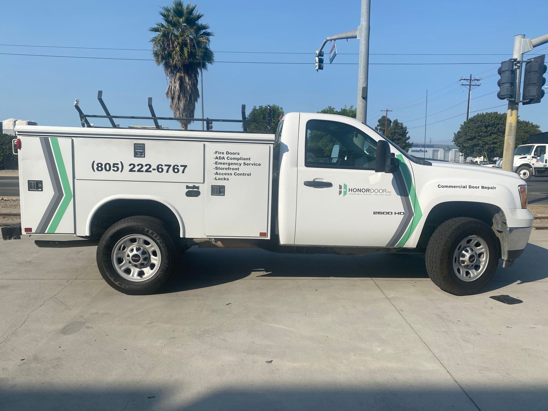 A white utility truck is parked on the side of the road.