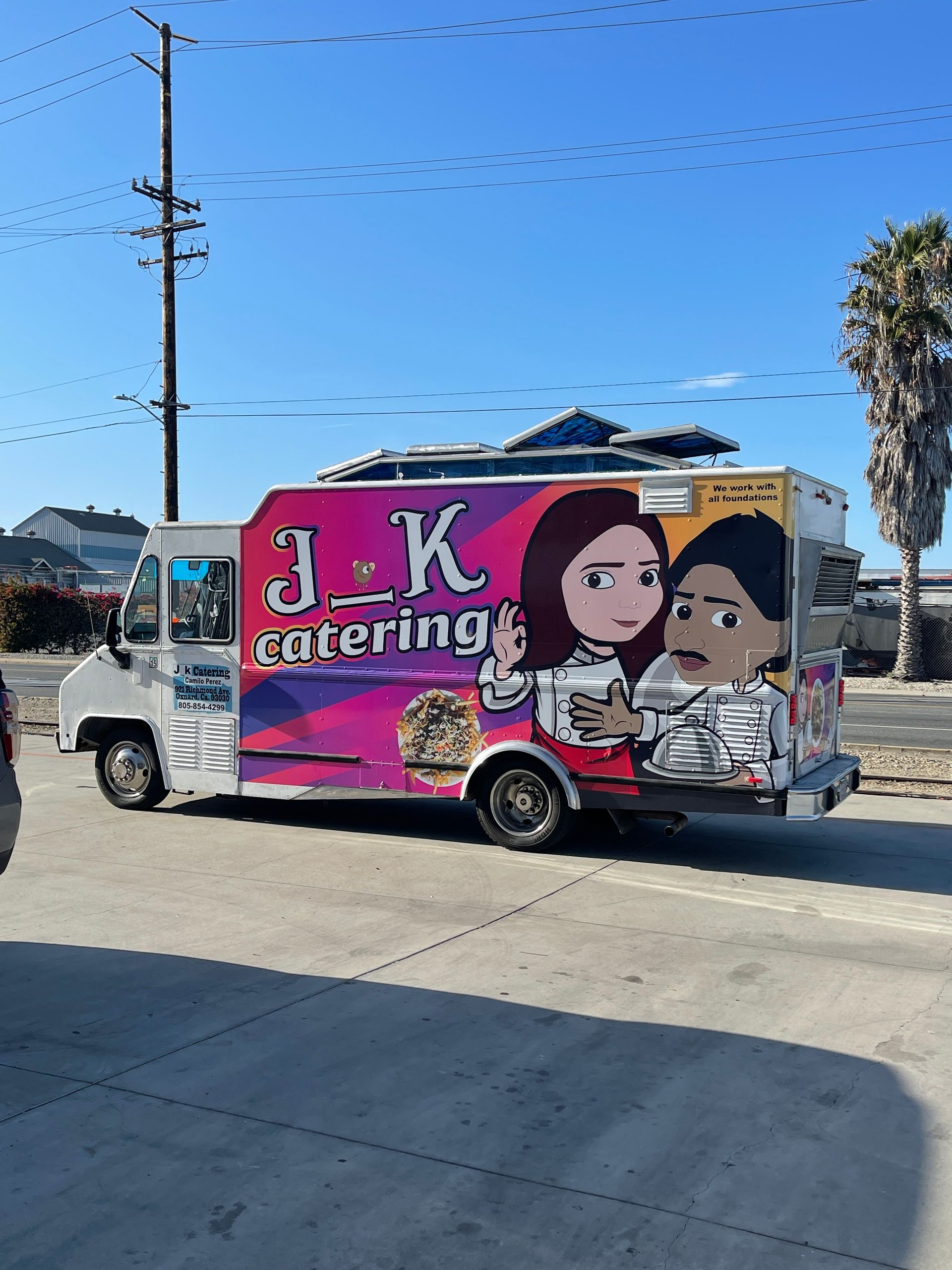 A j.k. catering food truck is parked in a parking lot.