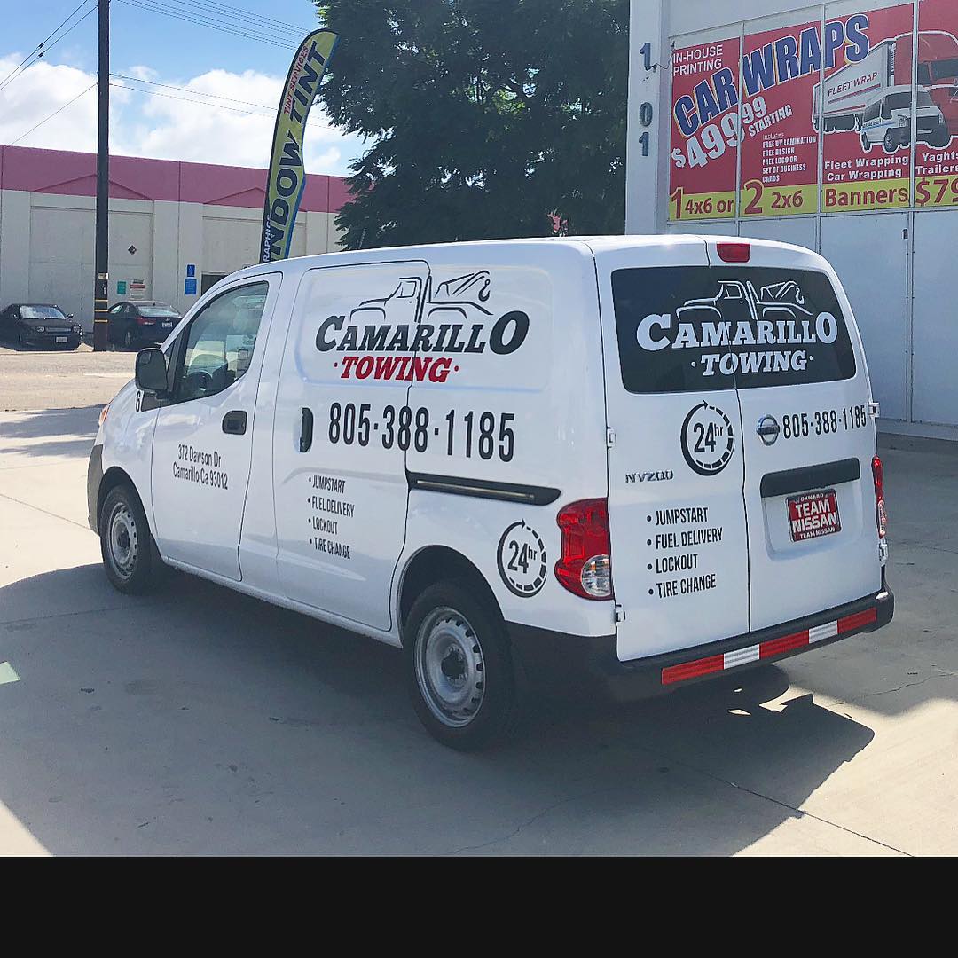 A white van is parked in front of a building that says camarillo towing