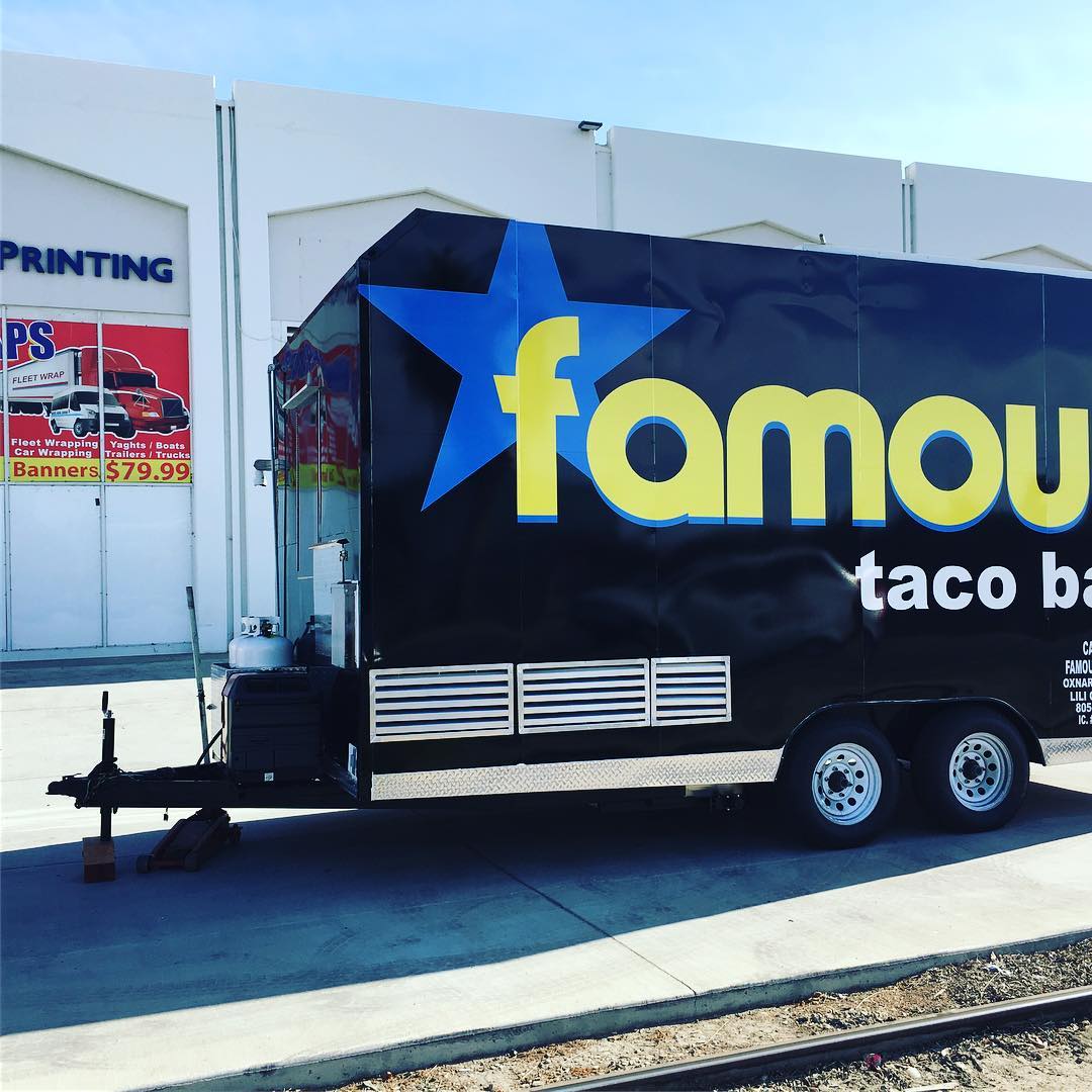 A famous taco truck is parked in front of a building