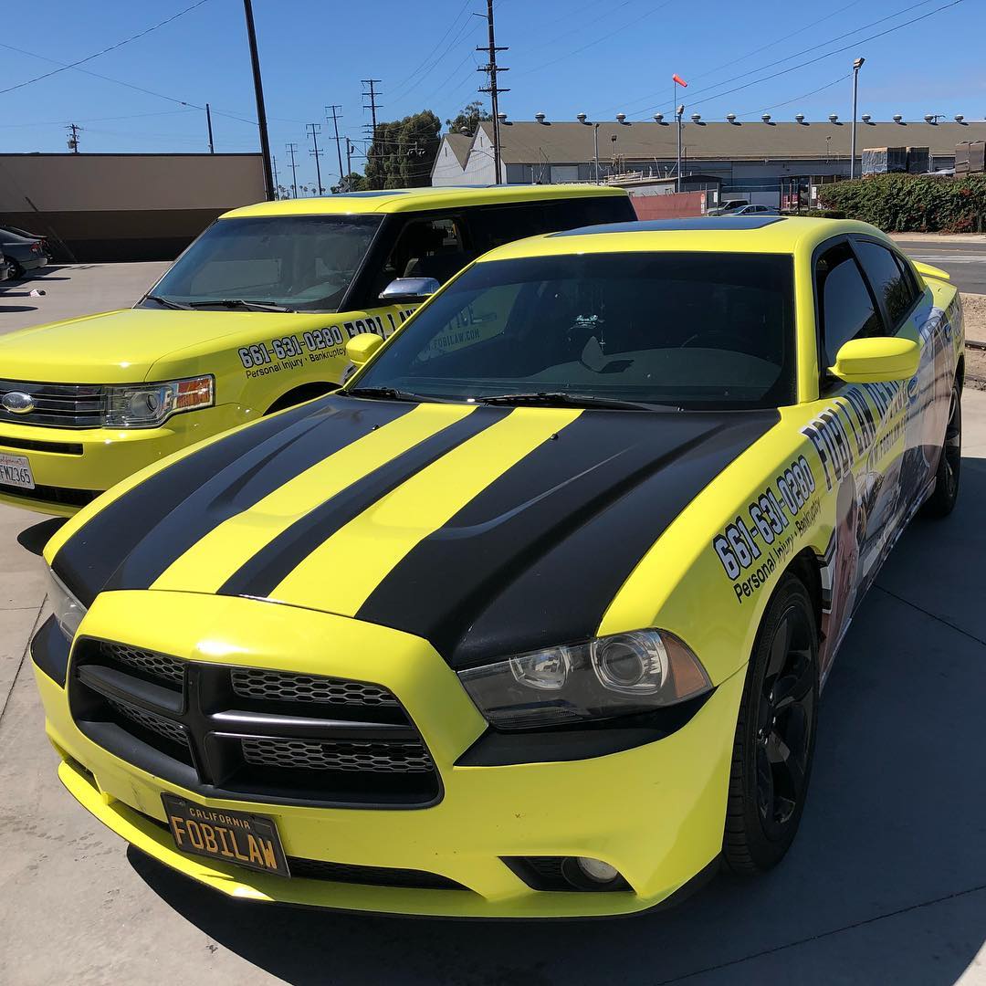 Two yellow cars with black stripes are parked next to each other