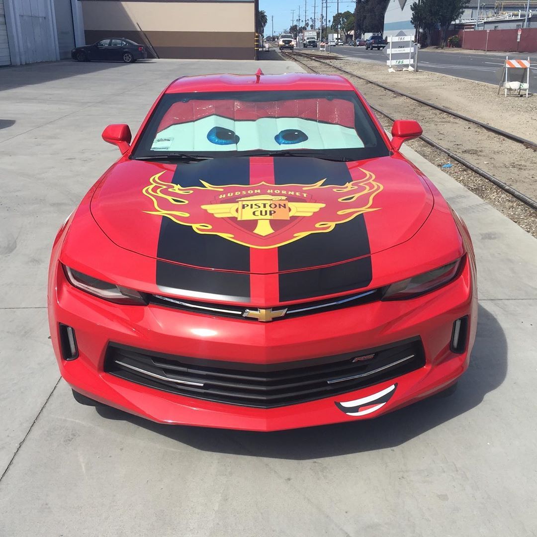 A red car with a sticker on the hood that says victory