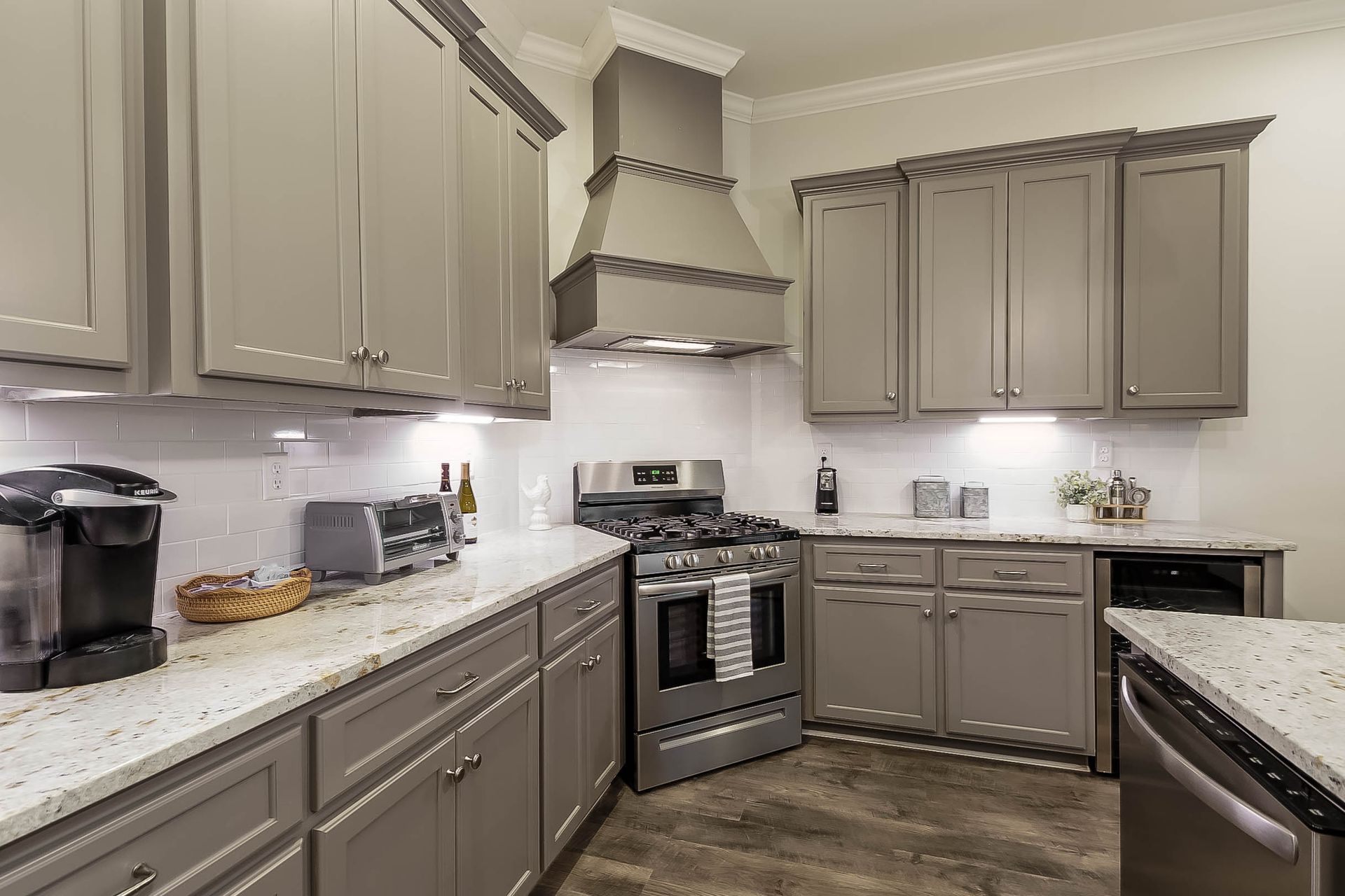Gray kitchen with cabinets, stainless steel appliances, and white countertops.