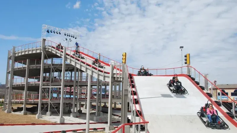 A group of people are riding go karts down a hill.