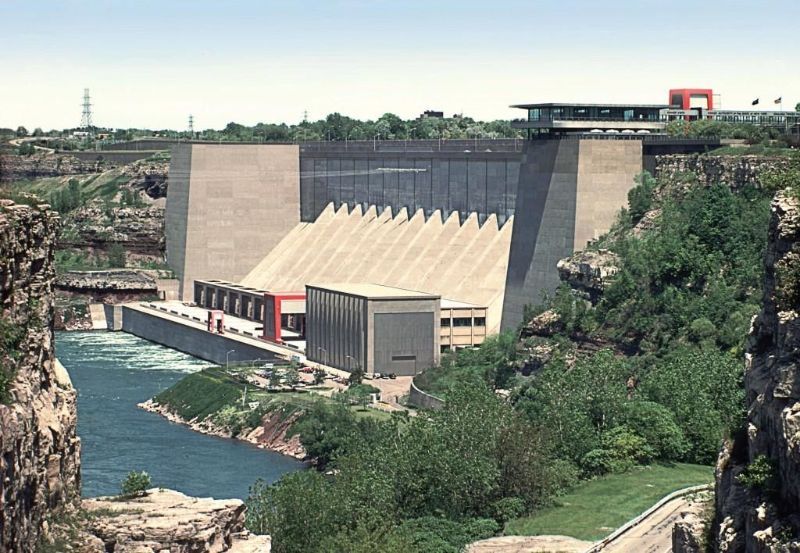 A large building sits on a cliff overlooking a river