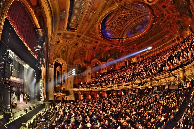 A large auditorium filled with people watching a concert
