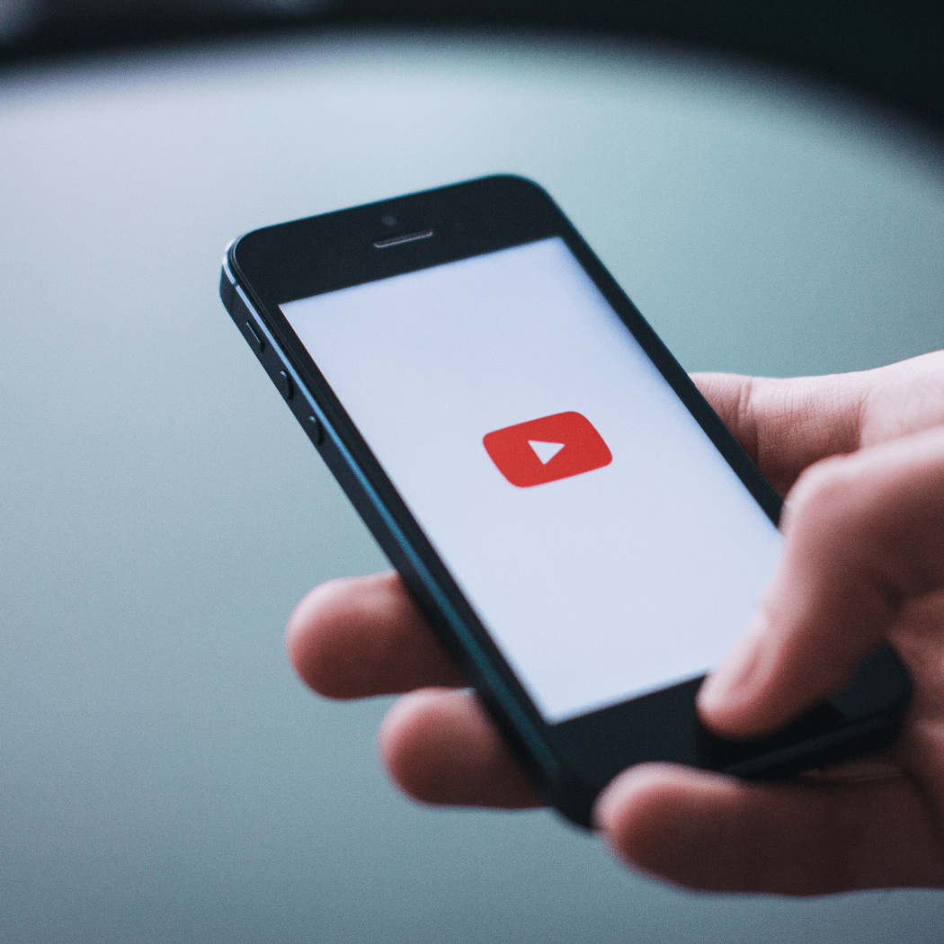 Person holding a smartphone displaying the YouTube app, representing Google Video Ads and YouTube marketing