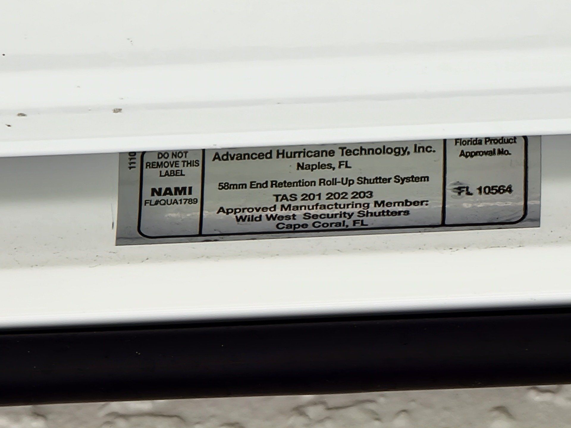 Label on white surface: Advanced Hurricane Technology, Inc. product information, with a NAMI certification, and a PL 10554.