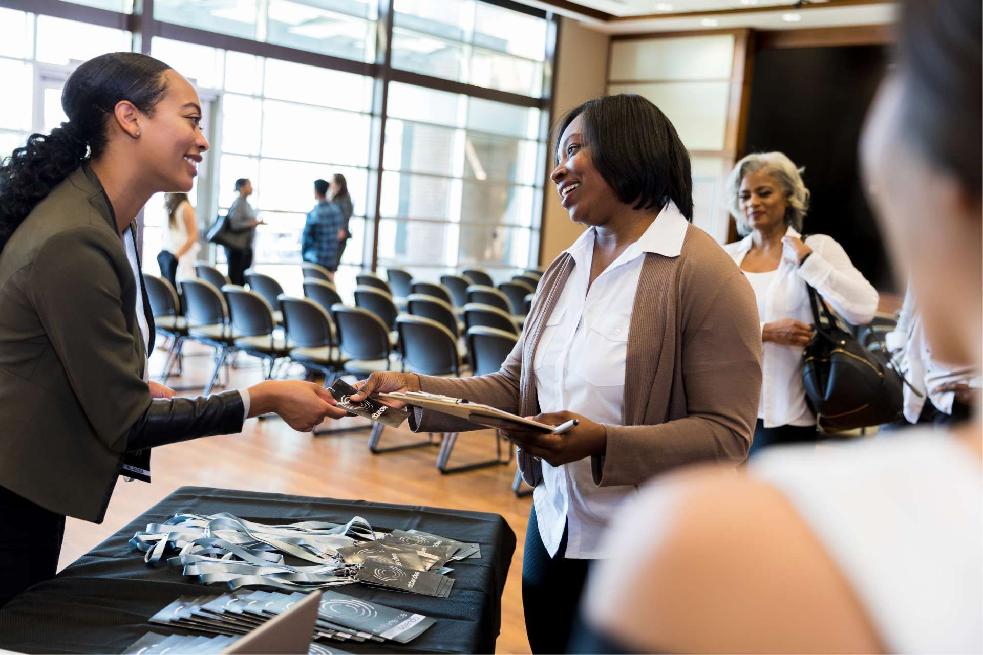 Adult women interacting at a check-in table