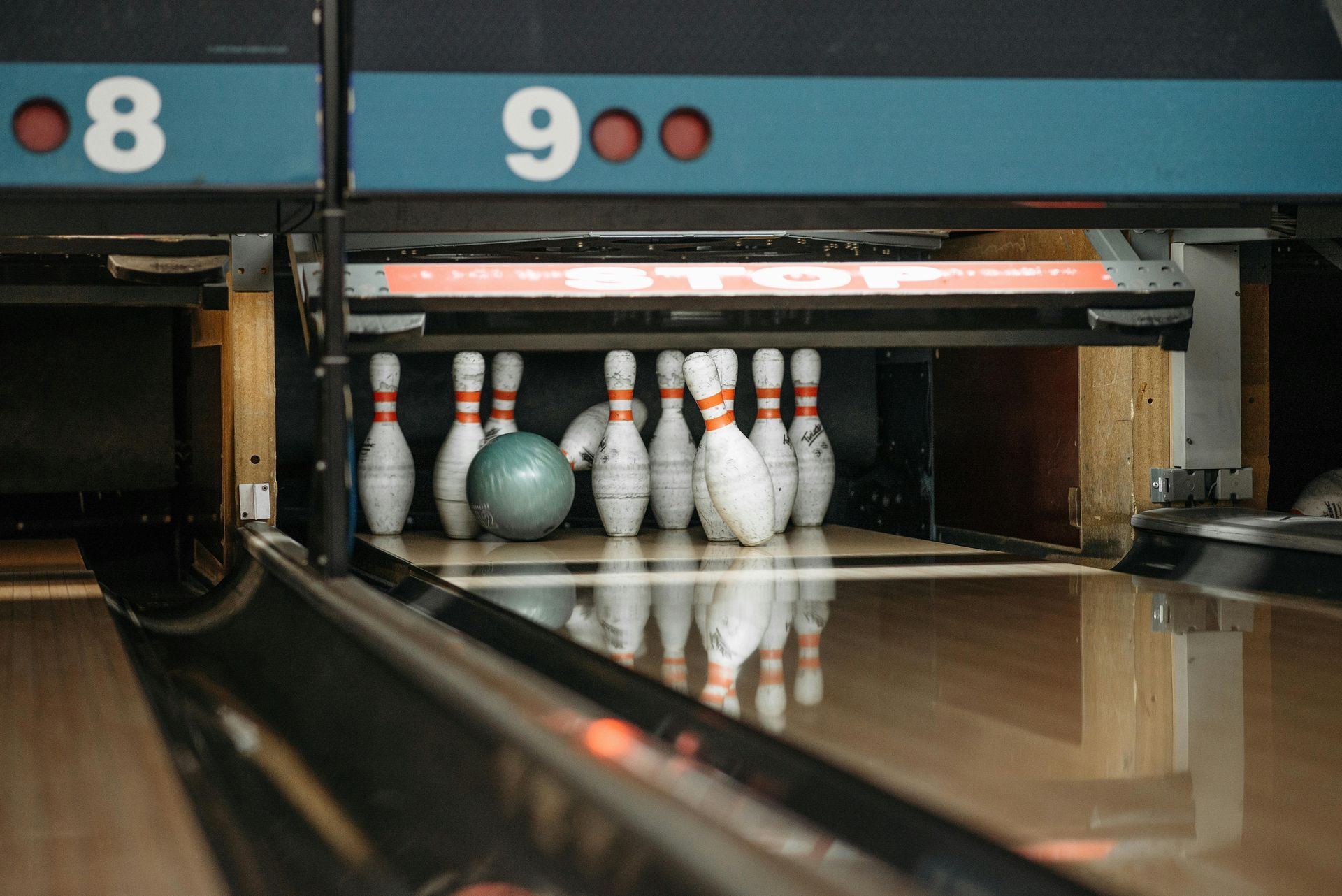 Bowling ball hitting pins in a bowling lane.