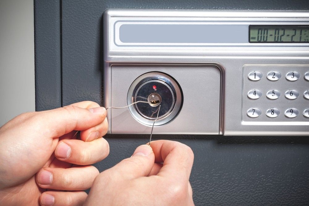 A Person is Opening a Safe With a Screwdriver — Suresafe Locksmiths in Glenvale, QLD