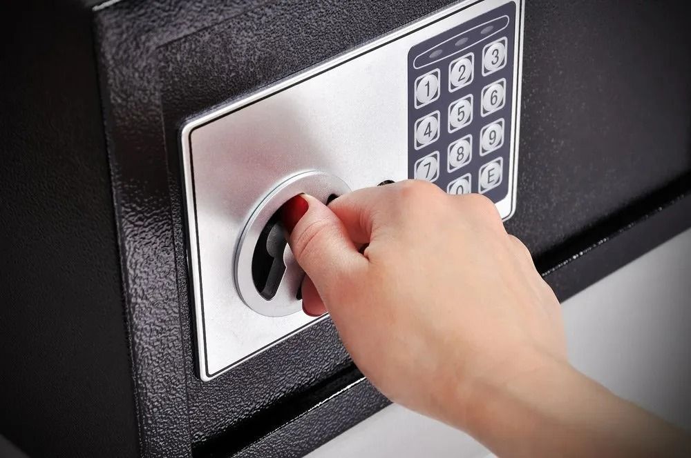A Person is Opening a Digital Safe With a Key — Suresafe Locksmiths in Glenvale, QLD