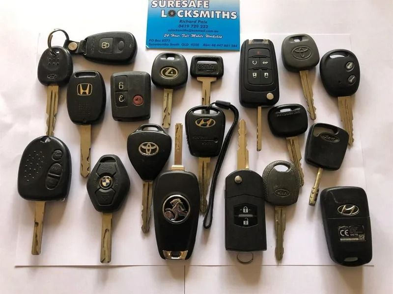 A Bunch of Car Keys on a Table With a Business Card — Suresafe Locksmiths in Glenvale, QLD