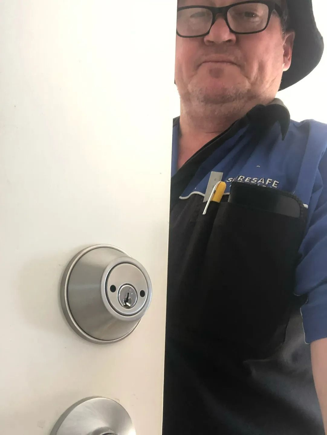 A Man is Sitting at a Desk in a Workshop Working on a Computer — Suresafe Locksmiths in Glenvale, QLD