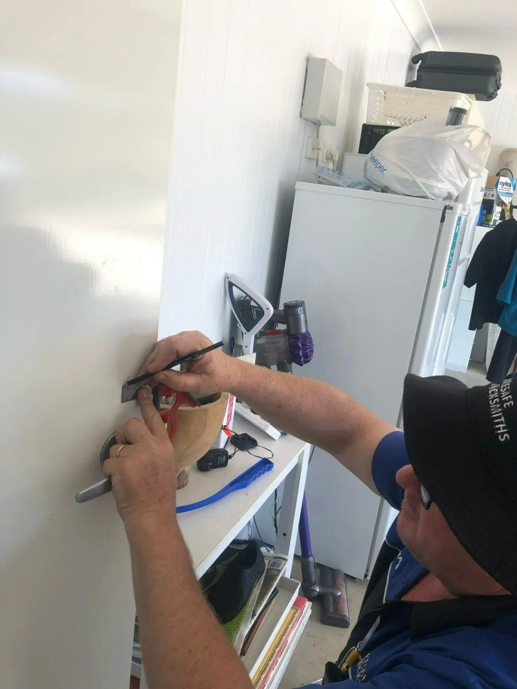 A Man is Working on a Door Knob — Suresafe Locksmiths in Glenvale, QLD