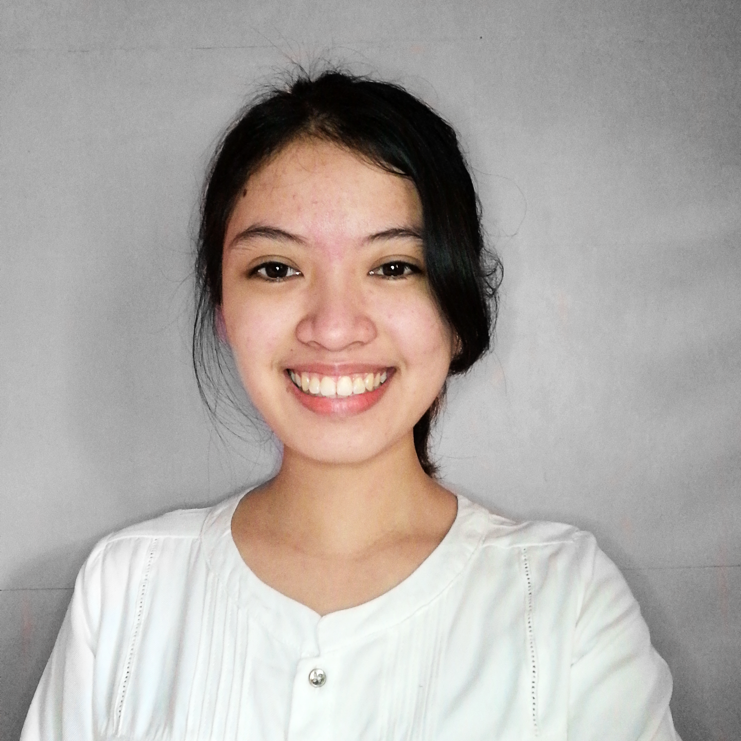 Portrait of a woman in a brown and white top against a warm orange background