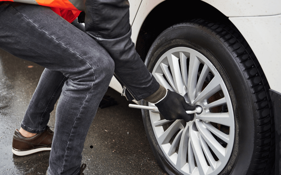 a roadside mechanic removing a car rim