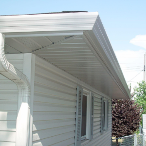 White house eaves and gutter downspout beside a window, seen from the side under a clear sky