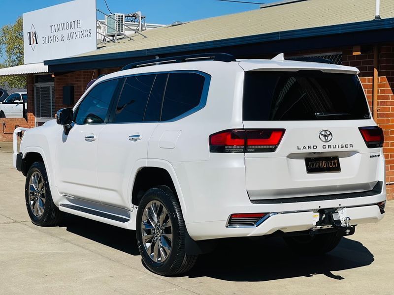 White Toyota Land Cruiser SUV Parked Outside a Dealership on a Sunny Day — Jake's Car Detailing in Taminda, NSW