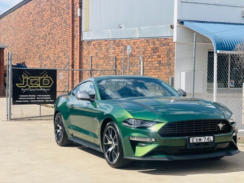 Green Ford Mustang Parked Outside an Industrial Building With a JCD Sign — Jake's Car Detailing in Taminda, NSW