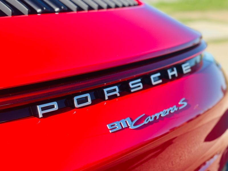 Close-up of a Red Porsche 911 Carrera Rear Badge and Taillight — Jake's Car Detailing in Taminda, NSW