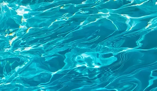 Bright turquoise water with sunlit ripples and gentle waves