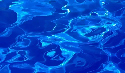 Blue rippling water with sunlight reflections