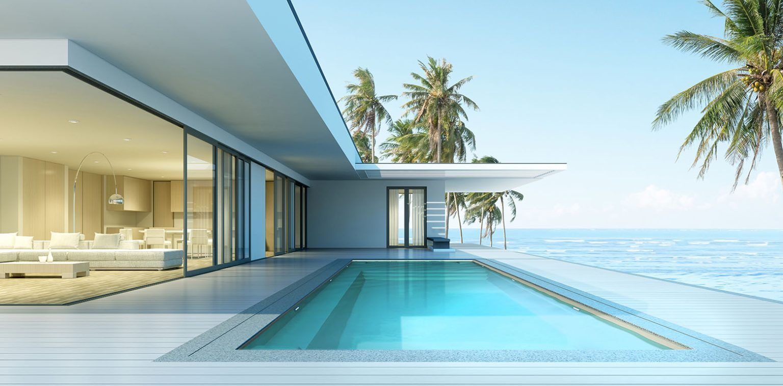 Modern beachfront villa with an infinity pool, glass walls, and ocean view