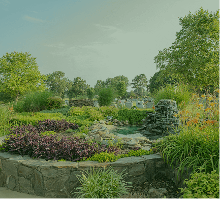 Lush garden with stone border, colorful plants, trees, and a small waterfall under a pale green sky