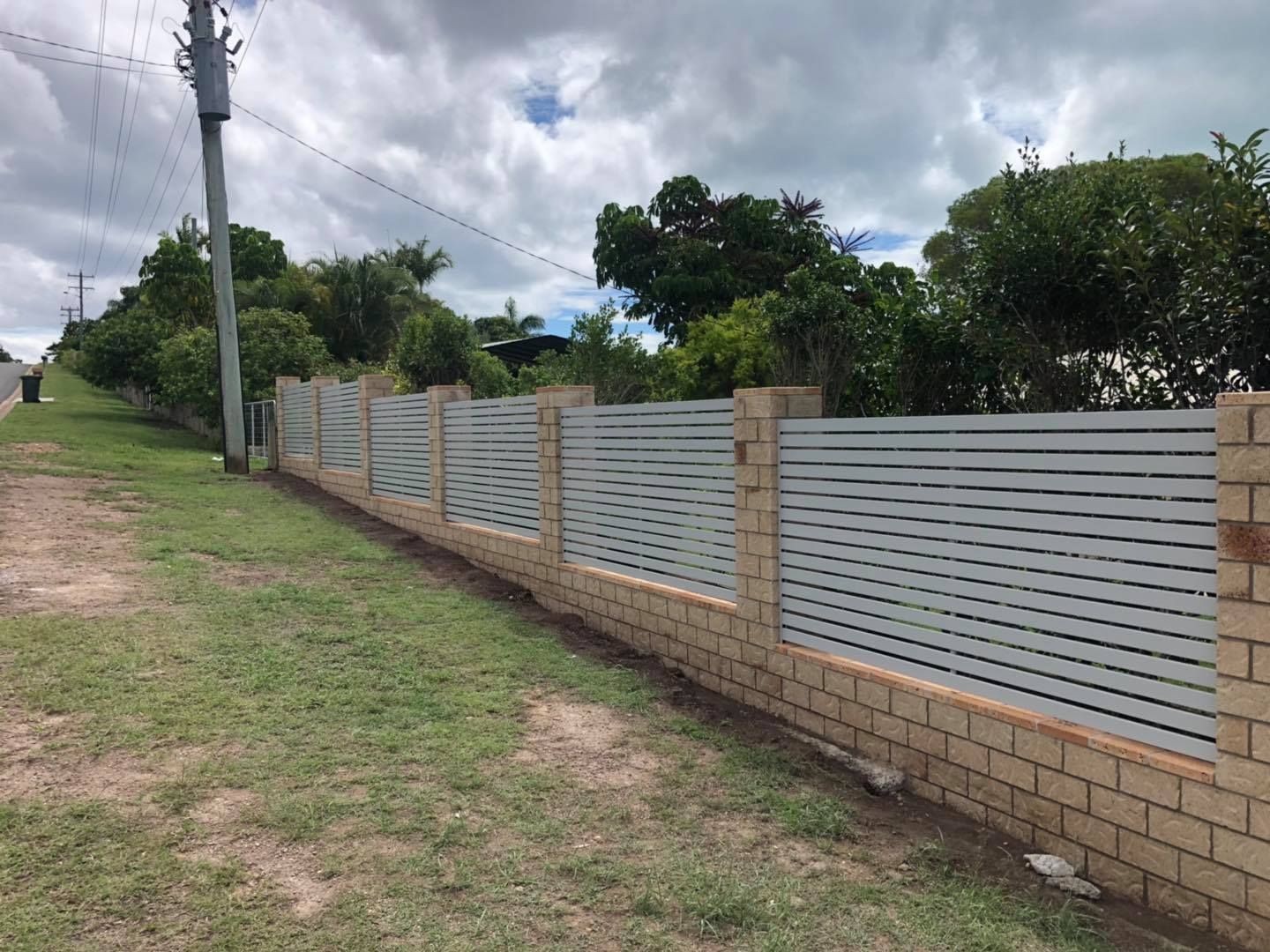 Barbed Wire Fence Surrounds a Road With Trees in the Background — Lange's Fencing & Landscaping Centre in Maryborough, QLD