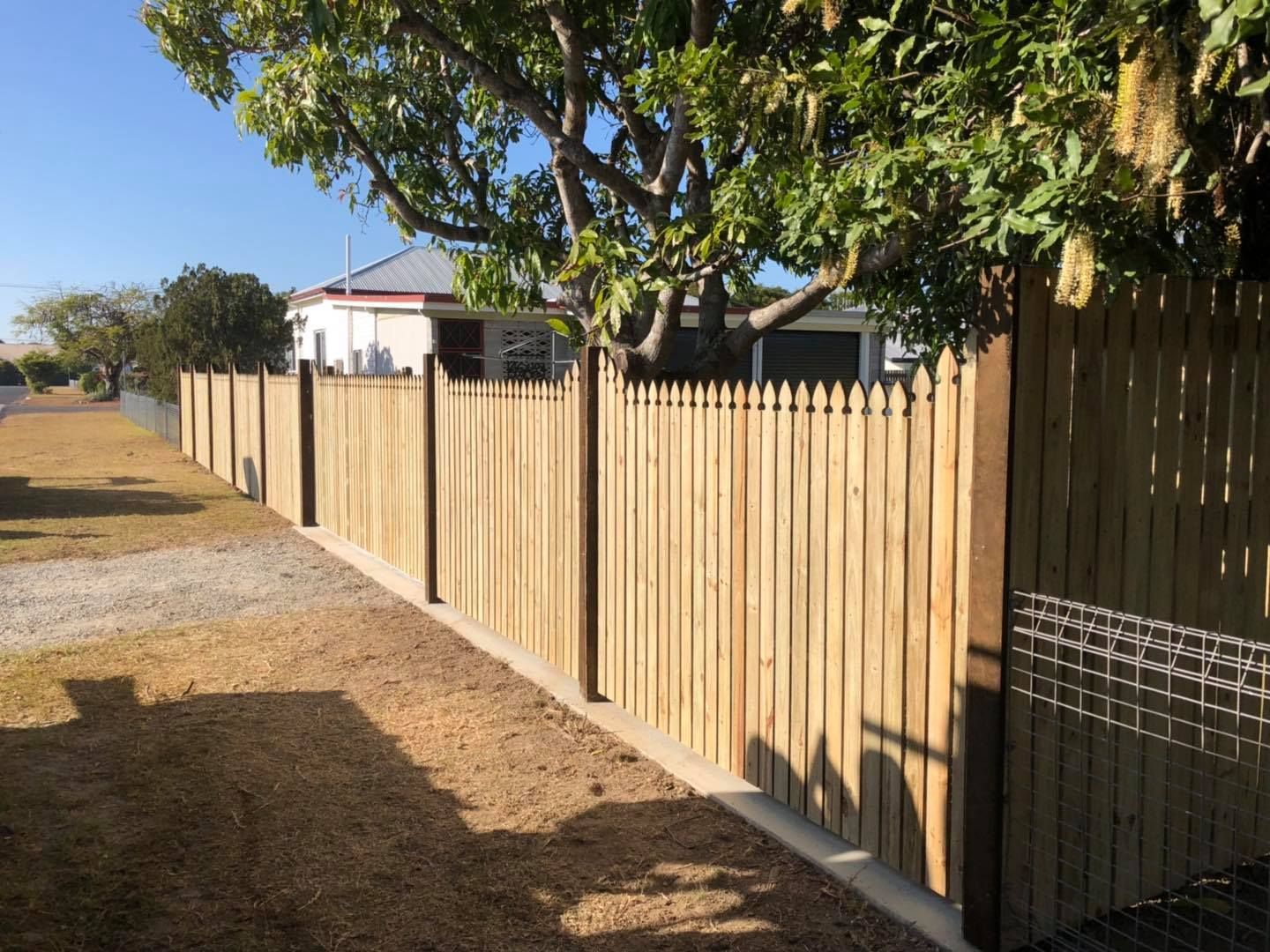 Wooden Fence With Pointed Tops, Next to a Sidewalk and Dirt — Lange's Fencing & Landscaping Centre in Island Plantation, QLD