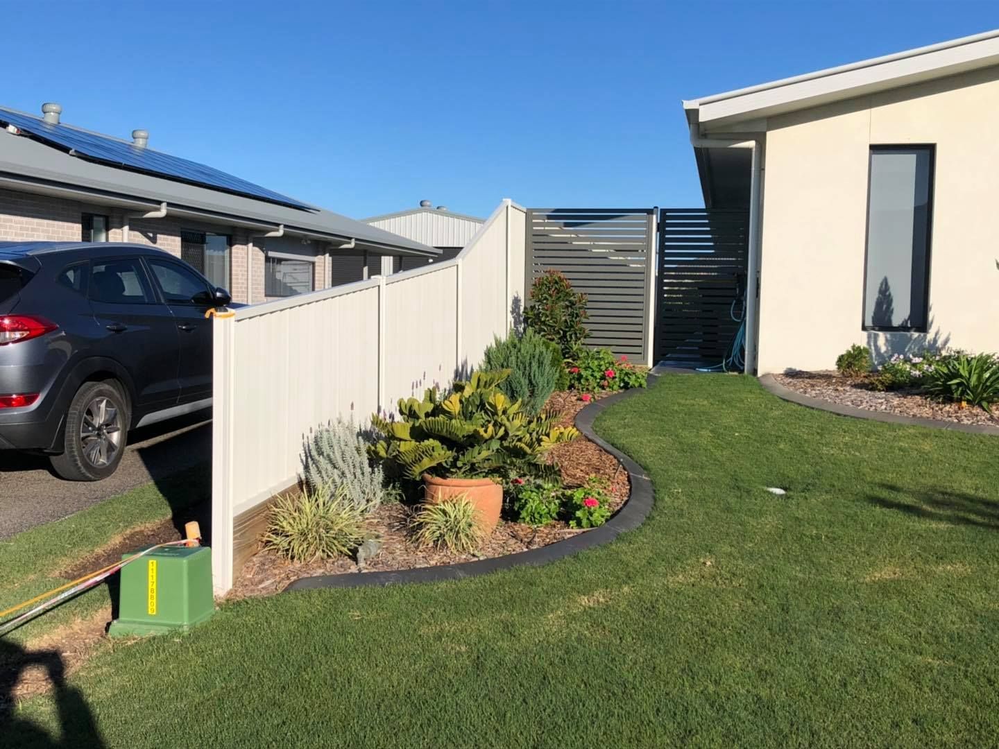 White Fence and Landscaped Garden Bed With Various Plants — Lange's Fencing & Landscaping Centre in Island Plantation, QLD