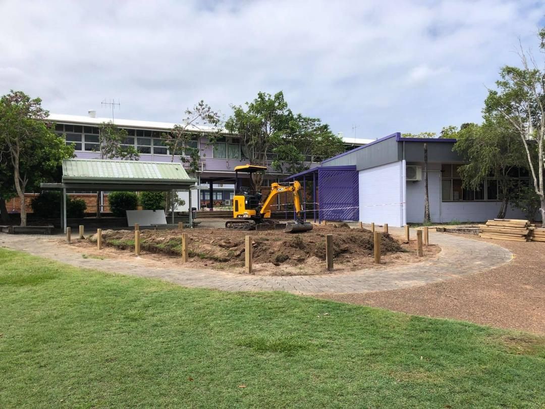 Yellow Excavator is Digging a Hole in Front of a Building — Lange’s Fencing & Landscaping Centre in Island Plantation, QLD