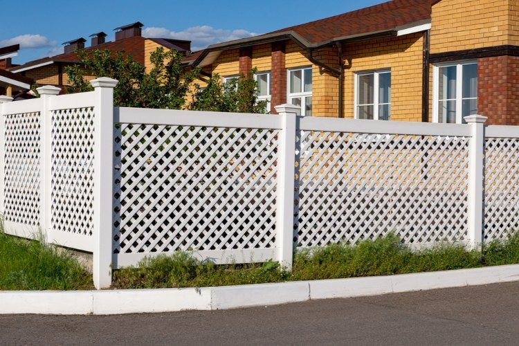 White Lattice Fence is in Front of a Brick House — Lange's Fencing & Landscaping Centre in Island Plantation, QLD
