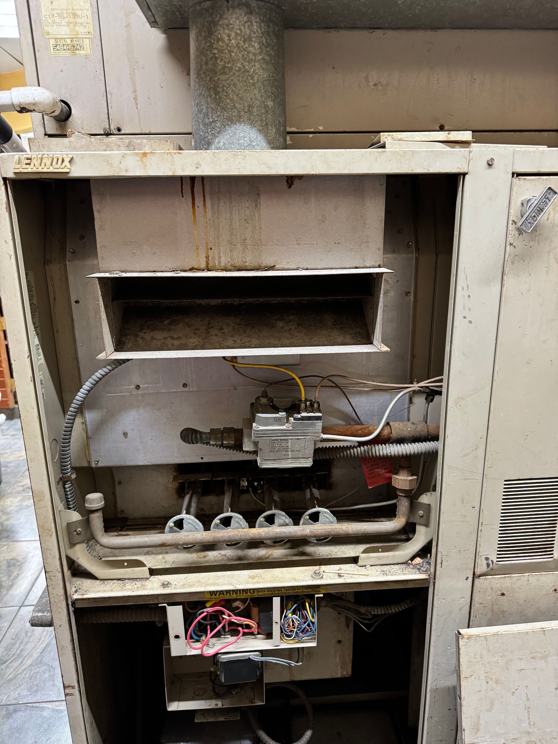 The inside of an old heater with a lot of wires coming out of it.