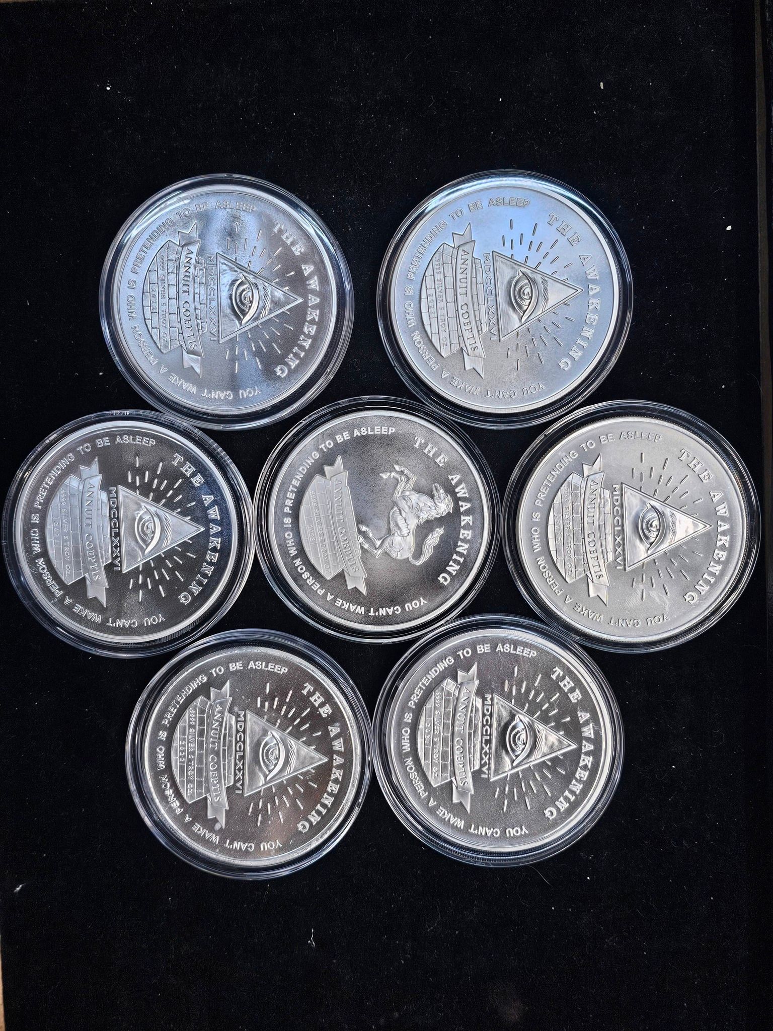 Six silver coins arranged in a hexagon on a black background.