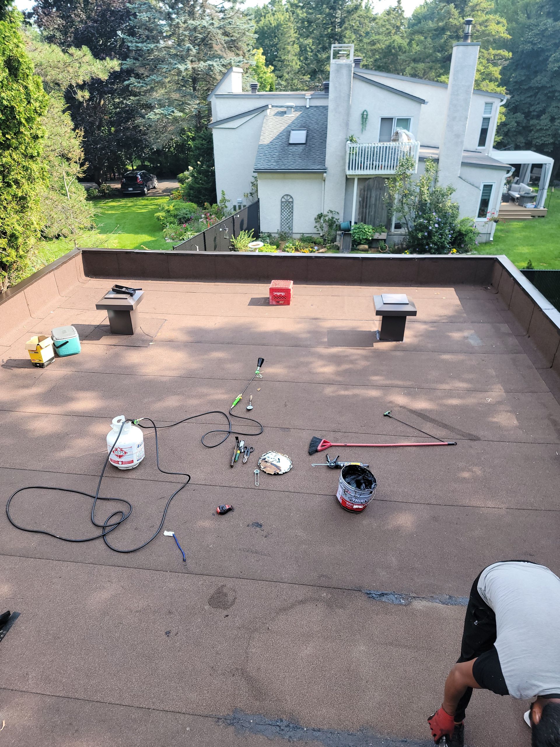 Un homme travaille sur le toit d'une maison.