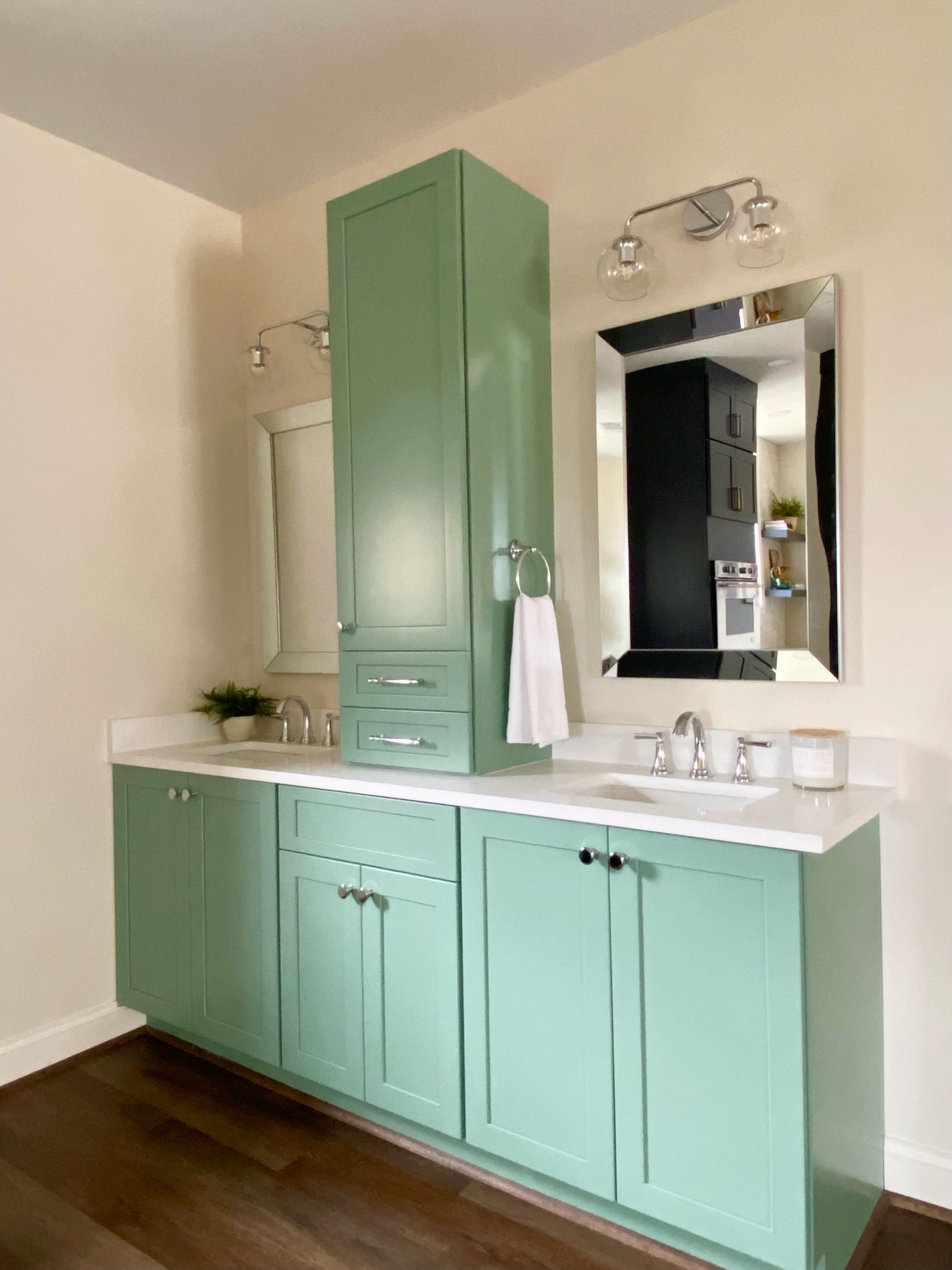 Bathroom with green cabinets, white countertop, and tall matching storage.