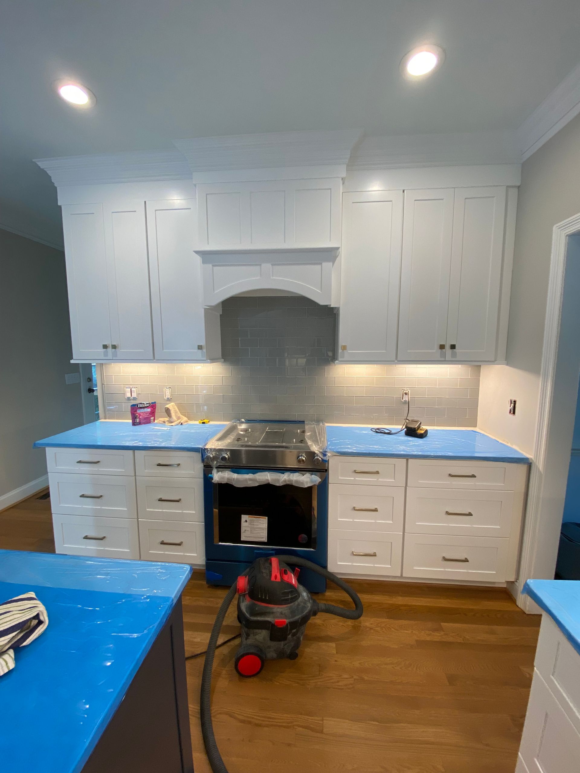 Kitchen with white cabinets, blue countertops, and a stove.