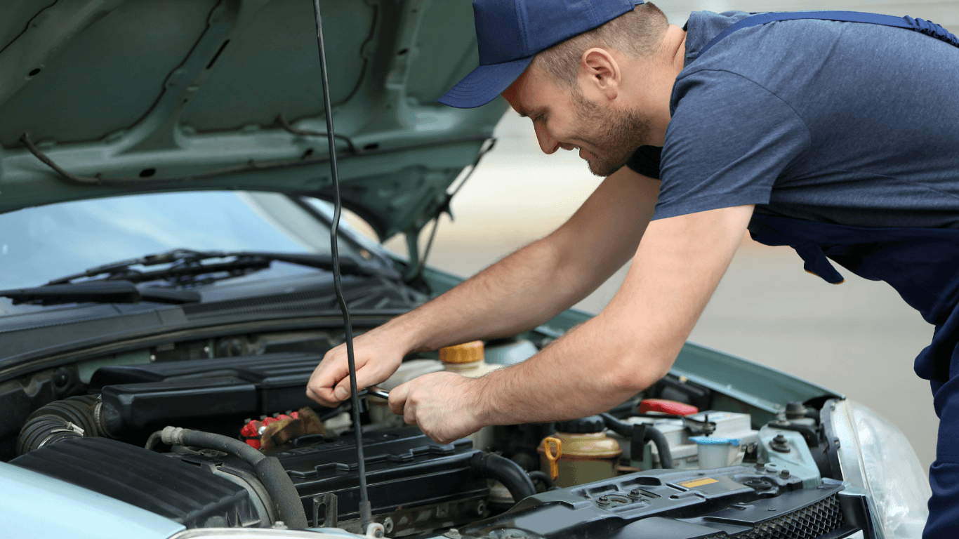 a mechanic working on a vehicle's engine roadside.