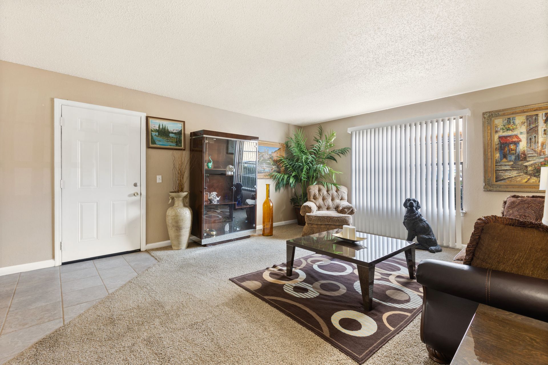 Living room with table, hutch, art, and tan walls.