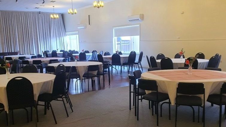 A large room with tables and chairs set up for a party