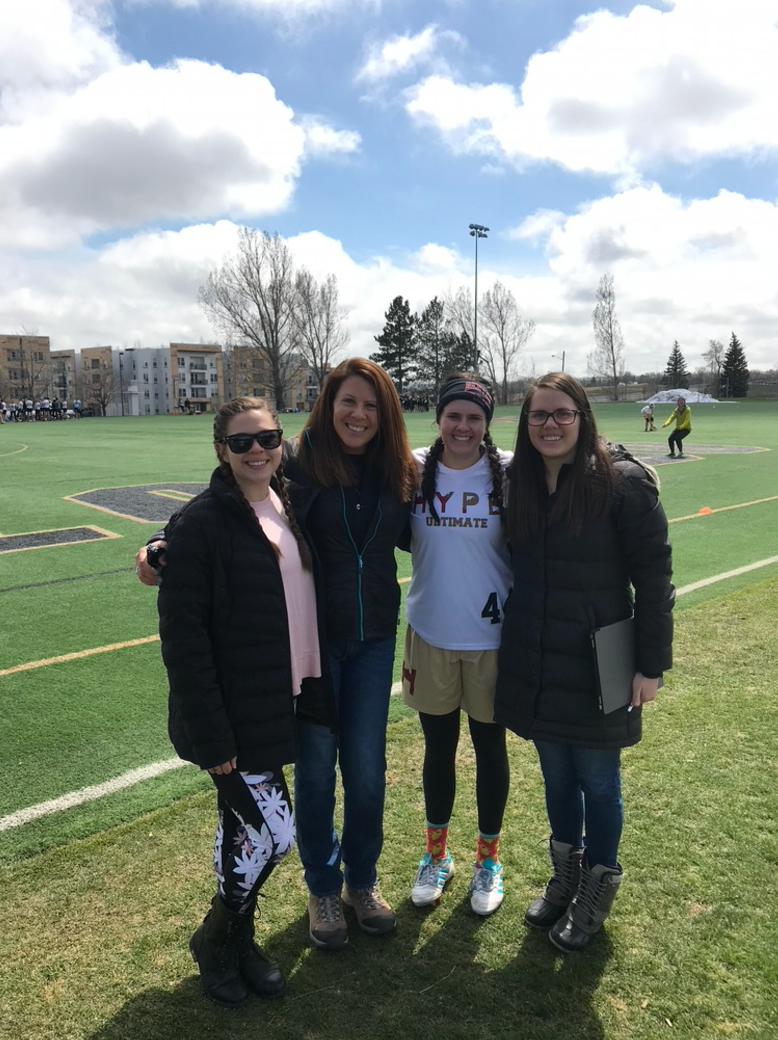 A group of women are posing for a picture on a field.