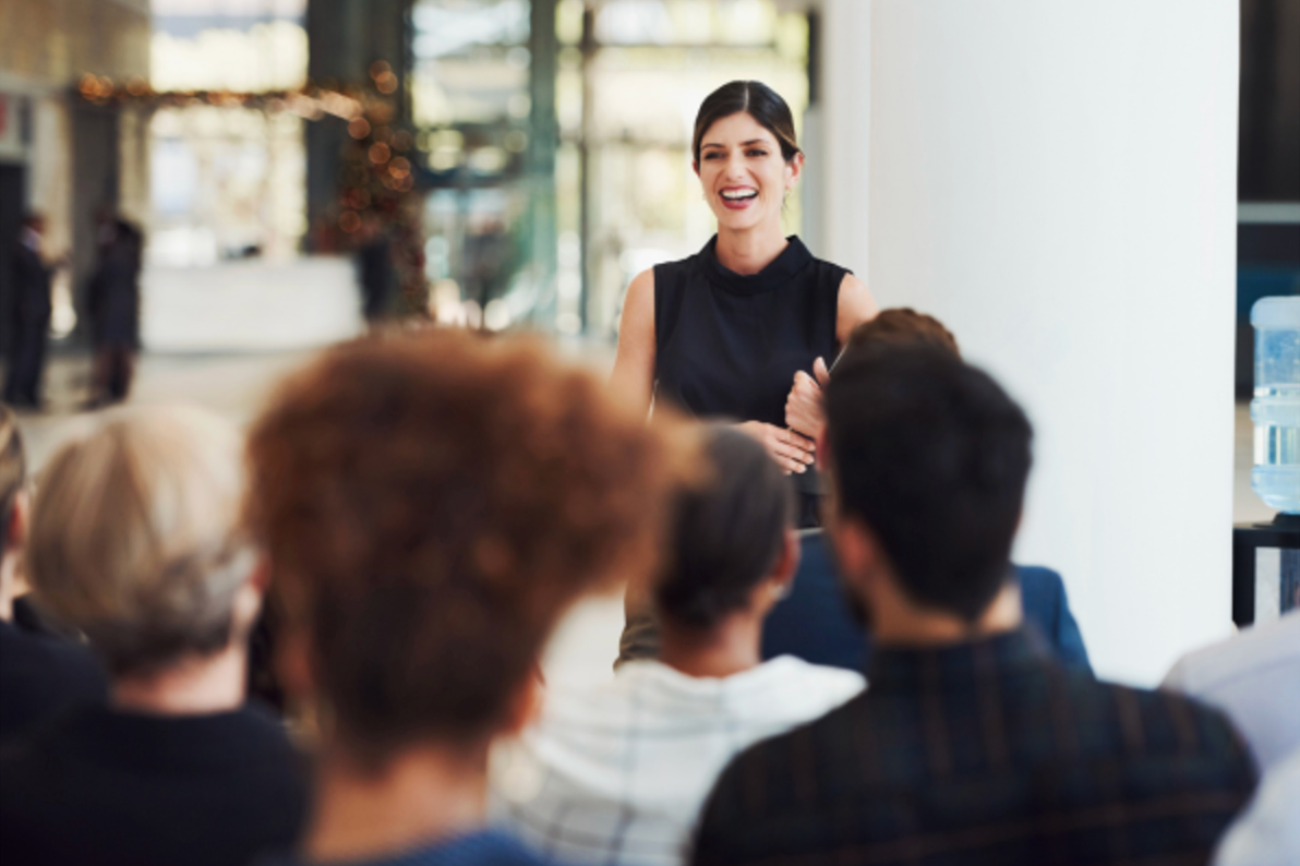 A woman is giving a presentation to a group of people.