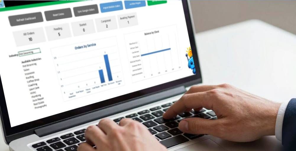 Hands typing on a laptop displaying a business dashboard with charts and data metrics.