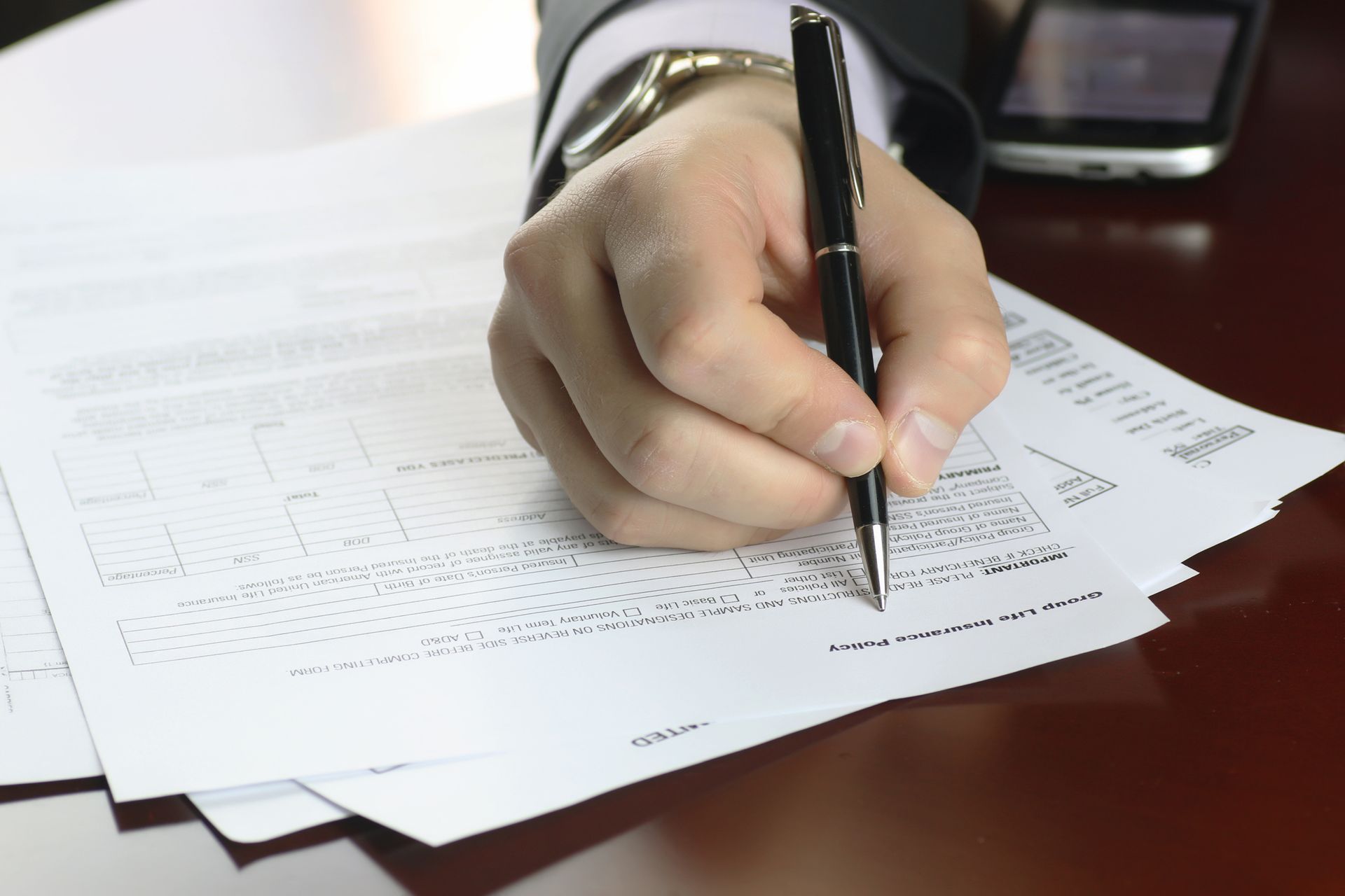 A person is writing on a piece of paper with a pen