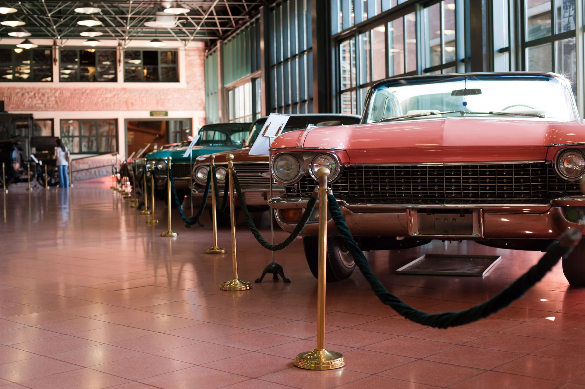 A row of old cars are lined up in a garage